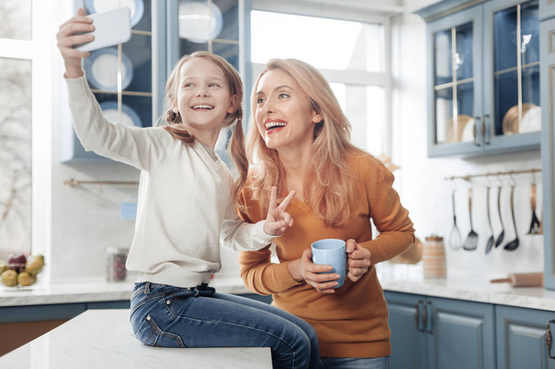 Joyful little girl taking picture with mom - Photo, image