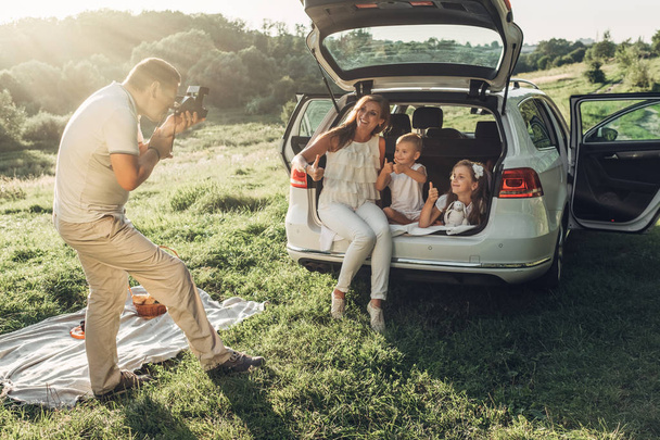 パーク外市、家族の週末の概念、4 人を楽しんで夏のピクニックを持つ小さな子供たちと大人のカップル - 写真・画像