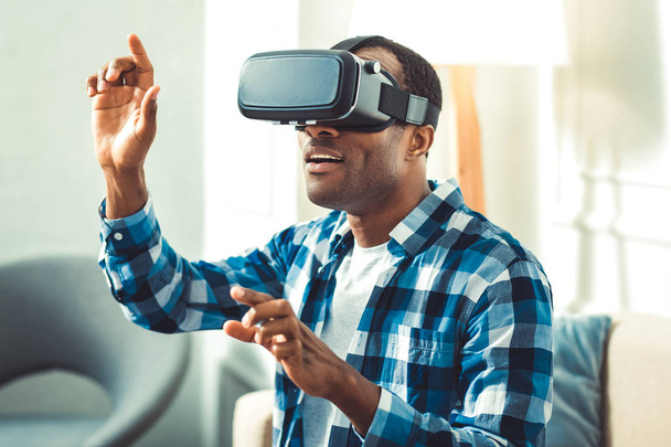 VR technologies. Attractive afro american man wearing VR headset and gesturing - Zdjęcie, obraz