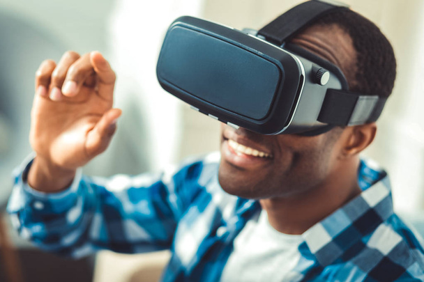 Optimistic young afro american man trying VR - Фото, изображение