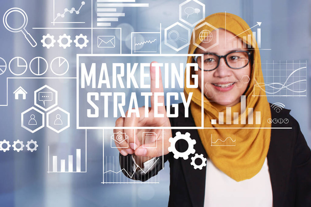 Business Concept. Smiling happy successful asian muslimah businesswoman click marketing strategy words on virtual screen. Modern Text typography design - Foto, imagen