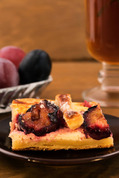 Portion of homemade cake with plums on a plate, close-up, vertical frame. - Photo, Image