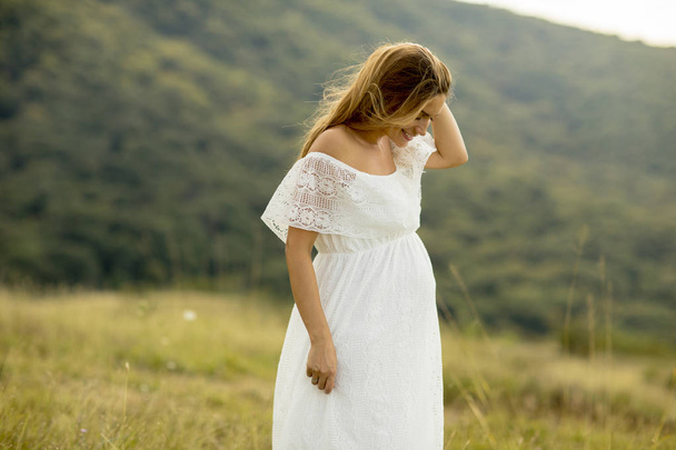 Fiatal terhes nő pihentető kívül a természetben, a nyári nap - Fotó, kép