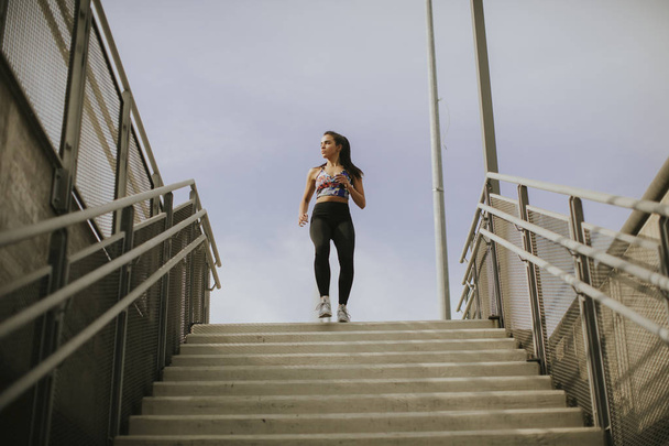 junge Frau rennt allein die Treppe hinunter - Foto, Bild
