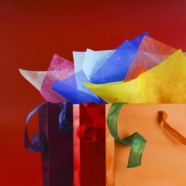 Színes bevásárló táskák, színes wrappnig papírok és a szalagok csendélet - Fotó, kép