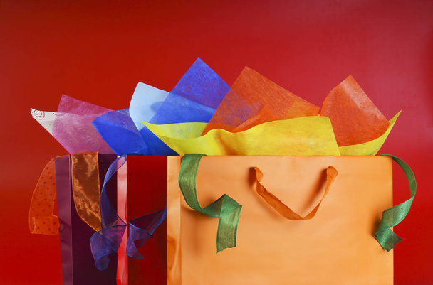 Bolsas de compras coloridas con papeles de envoltura coloridos y cintas naturaleza muerta
 - Foto, imagen