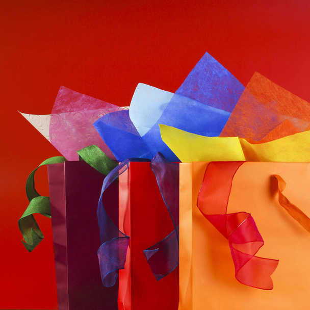 Színes bevásárló táskák, színes wrappnig papírok és a szalagok csendélet - Fotó, kép