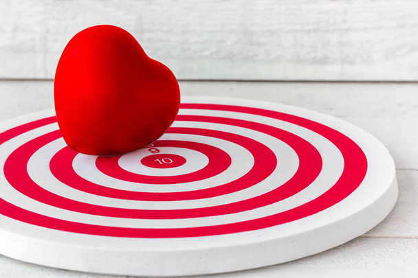 Κόκκινη καρδιά σε σχήμα κόκκινου βελακιού πάνω από λευκό φόντο ξύλου - Φωτογραφία, εικόνα