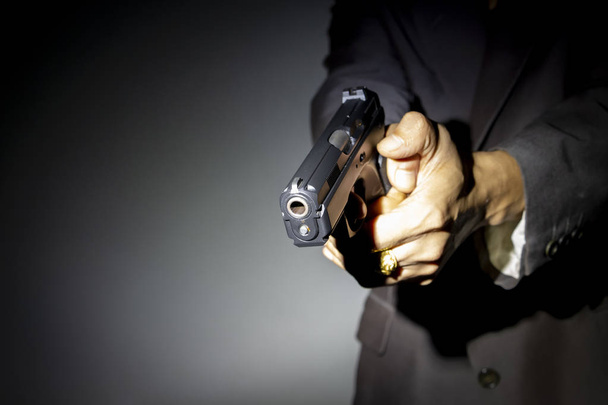 Крупним планом чоловіча рука тримає пістолет для стрільби
 - Фото, зображення