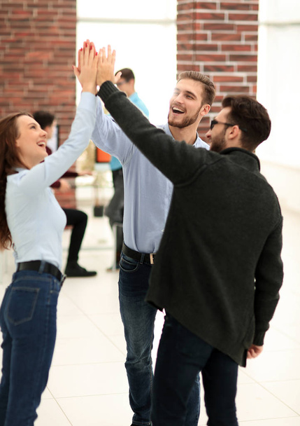 Les jeunes gens d'affaires joyeux donnant high-five tandis que leur coll
 - Photo, image