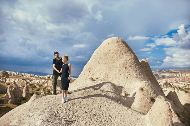 A szerelem és érzelmek szerető pár pihent, Törökország. Kappadókia-hegység keleti pár szerelmes ölelést és csókokat. Közelkép portré egy férfi és egy nő. Gyönyörű félhold fülbevaló a lány fülébe - Fotó, kép