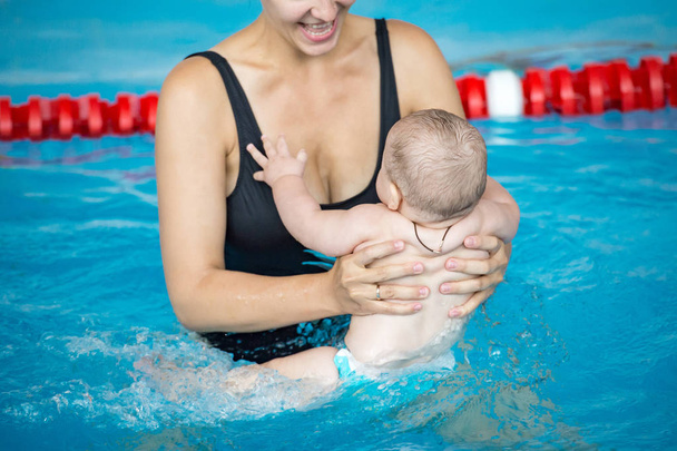 Mladá matka veselá a její malý syn v bazénu - Fotografie, Obrázek