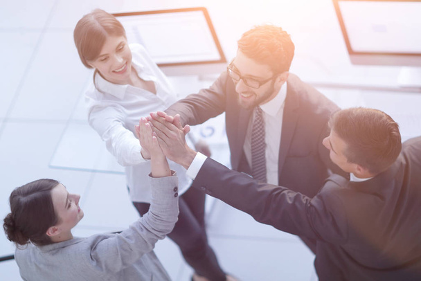 successful business team giving each other a high-five, standing in the office - Photo, Image