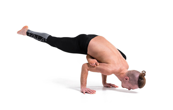A man doing yoga exercises. Studio shot over white isolated background.  - Photo, Image