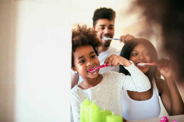 African american family washing teeth in the bathroom. - Φωτογραφία, εικόνα