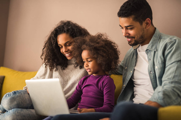 Portrait of happy african american family bonding with computer. - Фото, изображение
