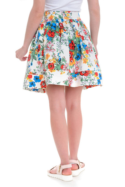 Summer fashion in skirt, with a flower pattern. Back female legs isolated Part of woman body. - Photo, Image