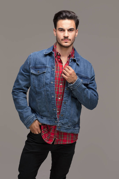 Handsome man posing in fashionable jeans jacket, studio indoors. - 写真・画像