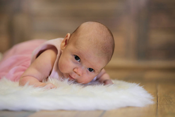 Newborn cute baby lying on white fur skin - Photo, Image