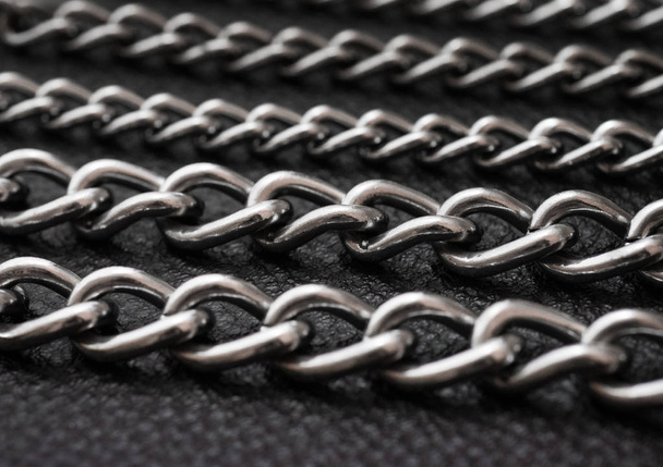Metal silver chains on luxury black leather texture. - Photo, Image