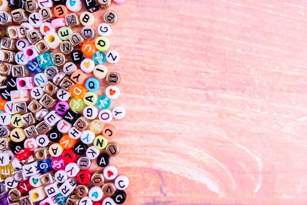 Dados coloridos do alfabeto plástico em um fundo de madeira como fundo
. - Foto, Imagem