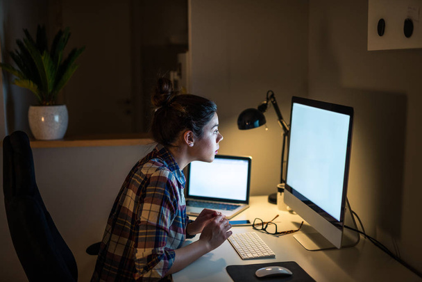 Young businesswoman working on the computer at late night shift. - 写真・画像