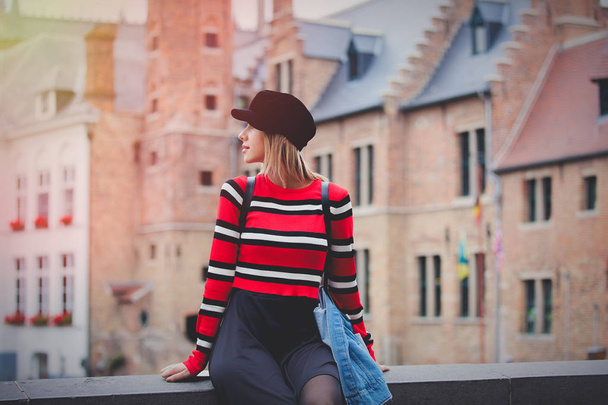 Jersey rojo de niña, con sombrero en las calles de Brujas, Bélgica. Temporada de otoño
 - Foto, imagen