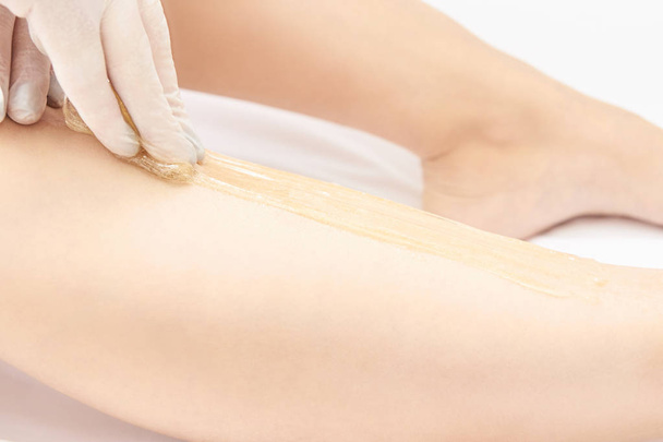 Waxing woman leg. Sugar hair removal. laser service epilation. Salon wax beautician procedure. - Foto, Imagen