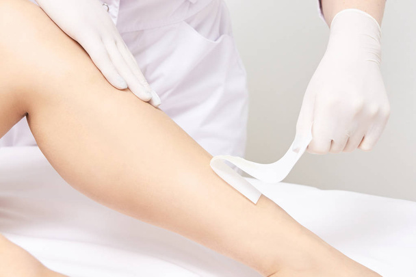 Waxing woman leg. Sugar hair removal. laser service epilation. Salon wax beautician procedure. - Фото, изображение