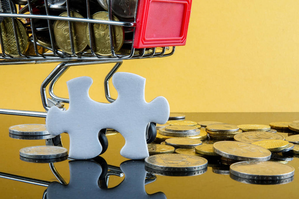 Trolley, Münzen und Puzzle mit Spiegelung auf gelbem Hintergrund. Verkaufs- und Einkaufskonzept - Foto, Bild