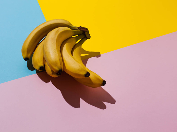 Plátano amarillo sobre fondo azul y rosa y amarillo
 - Foto, Imagen