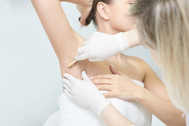 Waxing woman body. Sugar hair removal. laser service epilation. Salon wax beautician procedure. - Foto, afbeelding