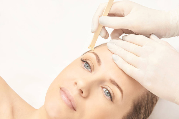 Sugar hair removal from woman body. Wax epilation spa procedure. Procedure beautician female. Eyebrow. - Zdjęcie, obraz