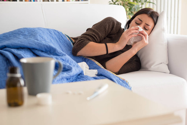 Retrato de mulher doente espirrando o nariz em casa
 - Foto, Imagem