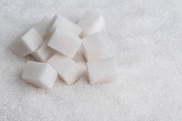Sokerikuutiot valkoisella sokerilla tausta
 - Valokuva, kuva