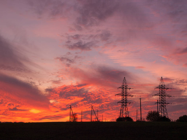 dramatique orange chaud coucher de soleil d'été ciel avec des tours de lignes électriques
 - Photo, image