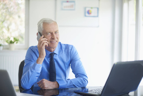 view of adult businessman using gadgets in modern office - Foto, Bild