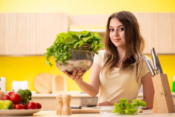 Young woman preparing salad at home in kitchen - Photo, Image