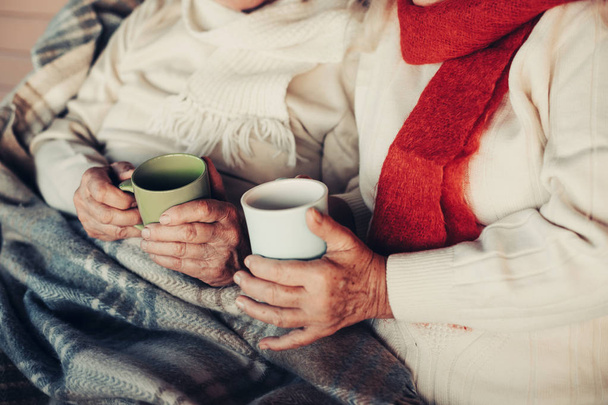 Focus on tea-cups in elderly wrinkled hands - Photo, Image