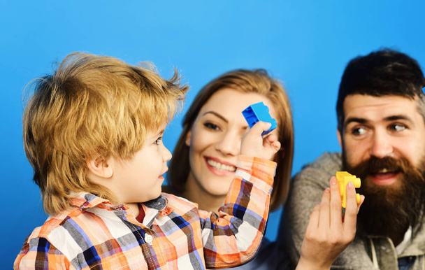 Parenthood and game concept. Man with beard, woman and boy play on blue background - Foto, Bild