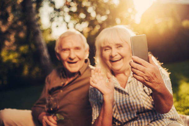 Cheerful mature grey haired couple making photo - Photo, image