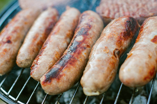 sausages and burgers cooking on the bbq - Photo, Image