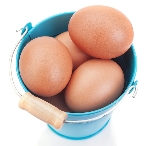 Chicken Easter eggs in a blue bucket. On a white background. - 写真・画像