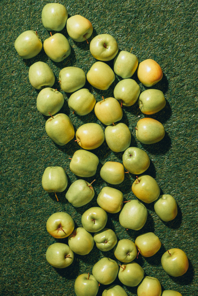Top näkymä vihreät omenat ruoho taustalla
  - Valokuva, kuva