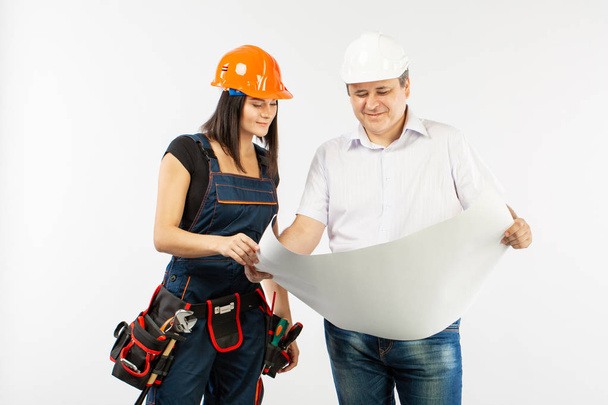 Porträt eines männlichen Architekten und einer Bauarbeiterin bei der Diskussion eines Bauplans. Polier mit Papierrollen - Foto, Bild