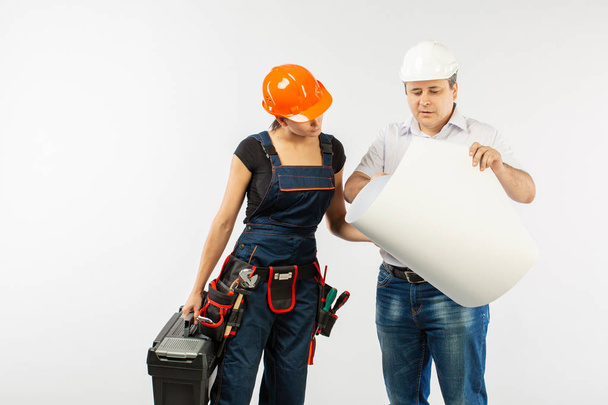 Portrait Of Male Architect And builder Woman Discussing building plan. foreman holding roll paper - Photo, Image
