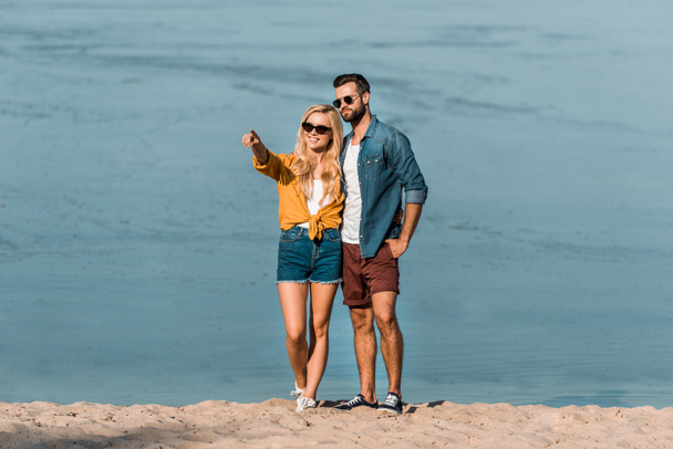 girlfriend pointing on something to boyfriend on beach - Valokuva, kuva