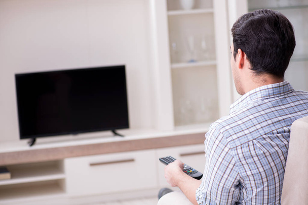 家でテレビを見ている若い男 - 写真・画像