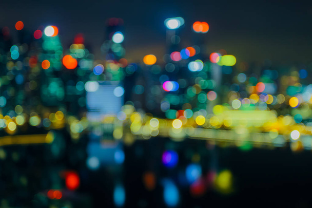 City lights bokeh blur effect at night. Unfocused blurred urban abstract background - 写真・画像