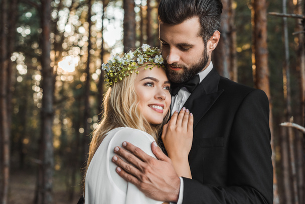 美しい結婚式のカップルを森でハグ  - 写真・画像